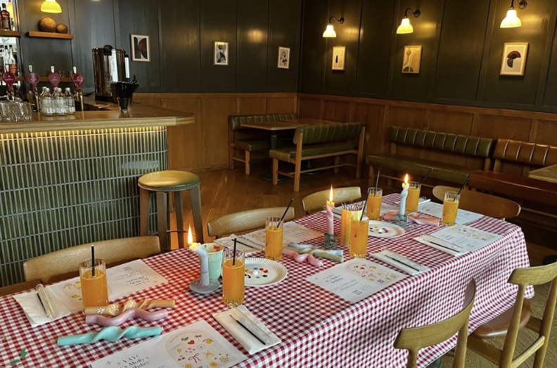 Gingham-set table laid with bendy candles and drinks for an office social workshop